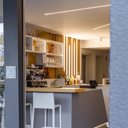 Interno moderno di un bar con luci calde e atmosfera accogliente.