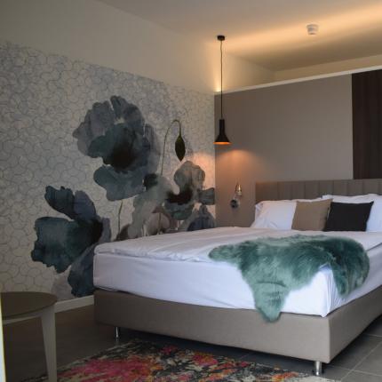 Camera moderna, elegante, con letto accogliente e decorazioni floreali artistiche.
