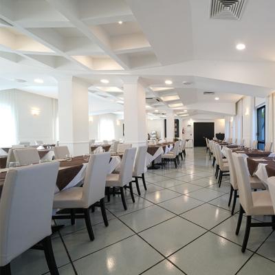 Elegante ristorante con tavoli apparecchiati e ampie finestre.