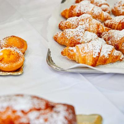 Croissant e dolci spolverati di zucchero a velo su un vassoio.