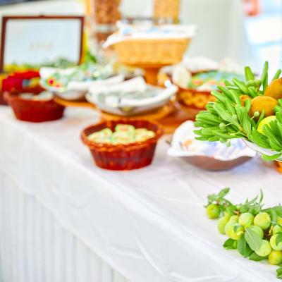 Un tavolo da buffet con frutta e decorazioni verdi.