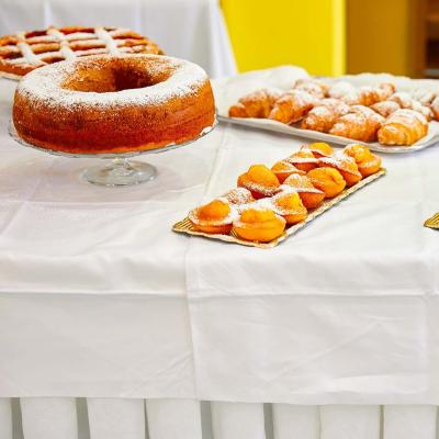 Dolci vari su un tavolo bianco, cosparsi di zucchero a velo.