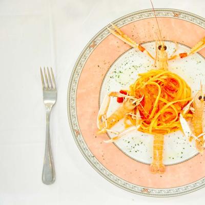 Piatto di linguine con scampi su tavola apparecchiata.