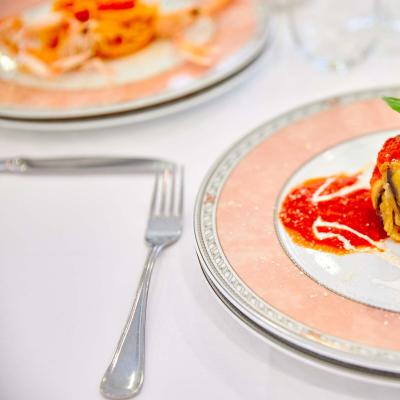 Piatto elegante con involtino di melanzane e salsa di pomodoro.