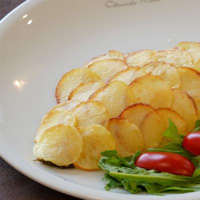 Patate a fette con insalata e pomodorini su piatto.