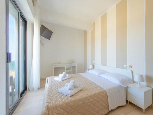 Bright room, cozy bed, sea view, relaxing and welcoming atmosphere.