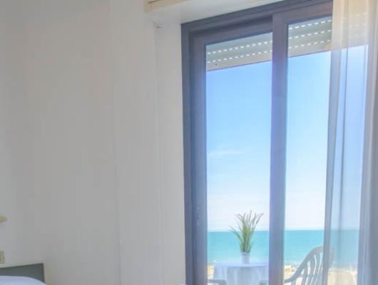 Bright room with sea view, soft linens, and a relaxing atmosphere.
