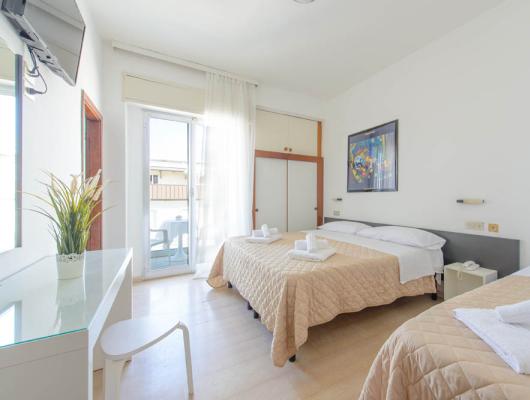 Bright, cozy room with neat beds and a sunny balcony.