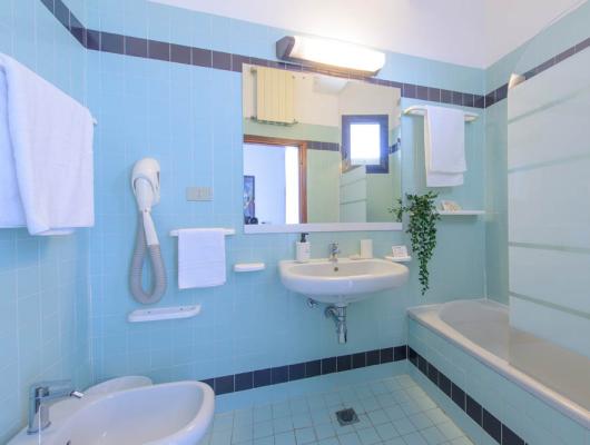 Bright, tidy bathroom with blue tiles and modern details.