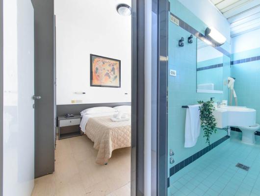 Elegant room and bright bathroom with blue tiles, relaxing and welcoming atmosphere.