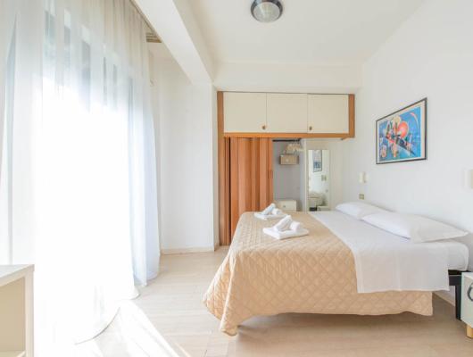 Bright, cozy room, double bed, vibrant art, serene atmosphere.