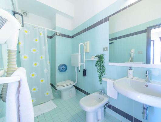 Bright bathroom with blue tiles and floral details, cozy and fresh.