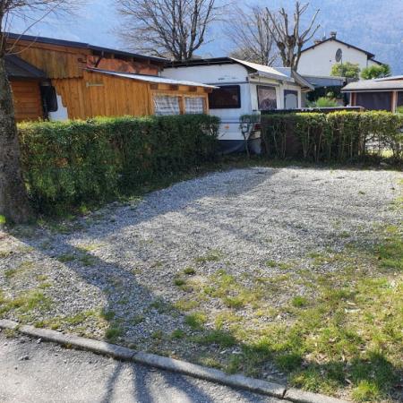 Piazzola per camper con ghiaia e siepi.