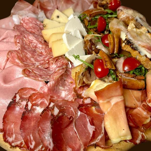 Tagliere di salumi, formaggi e bruschette con pomodorini.