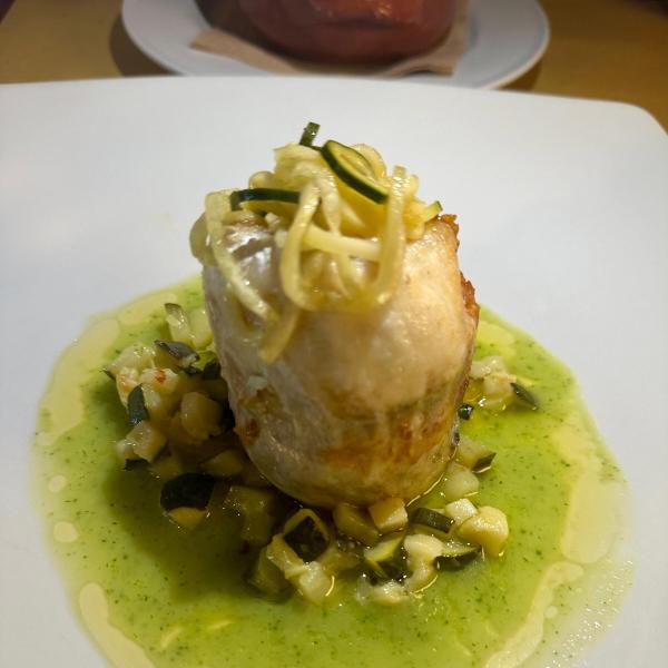 Filetto di pesce con verdure su salsa verde.