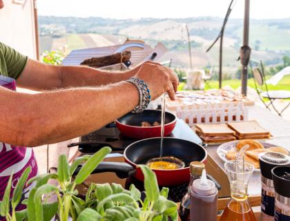 Preparazione della colazione all'aperto con uova e pane tostato.