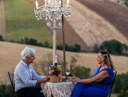 Cena romantica all'aperto con vista sui campi ondulati.