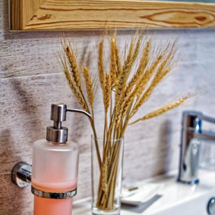 Bagno elegante con dispenser, spighe e cesto di prodotti.