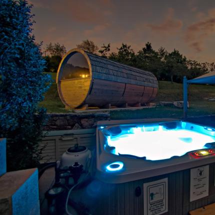 Vasca idromassaggio e sauna all'aperto sotto il cielo notturno.