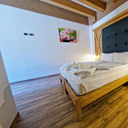 Camera accogliente con letto matrimoniale e arredamento in legno.