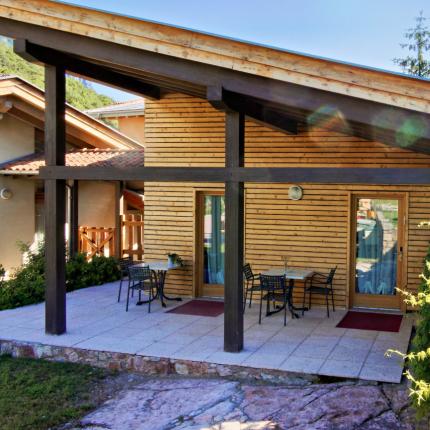 Casa moderna in legno con terrazza, immersa nel verde.