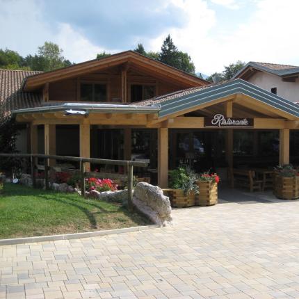 Ristorante con veranda in legno e fiori colorati.