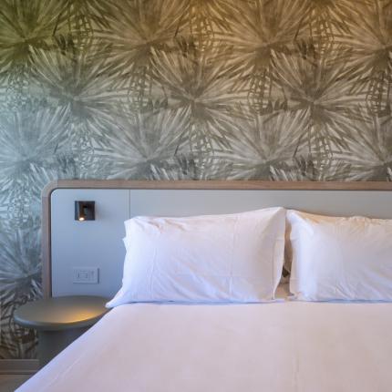 Elegant room with white bed and decorated wall, relaxing atmosphere.
