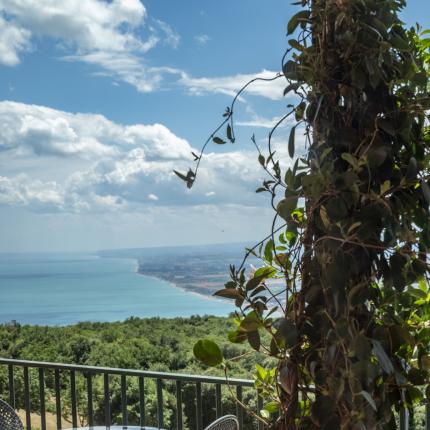 Breathtaking sea view from a terrace with table and chairs.