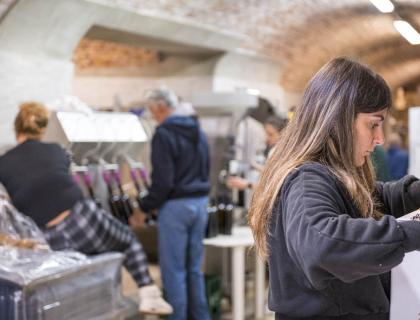 Persone impegnate in una cantina, atmosfera di lavoro e concentrazione.