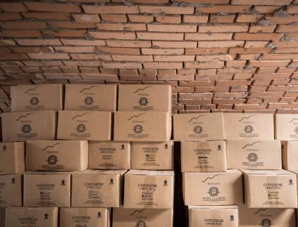 Scatole di vino sotto un soffitto di mattoni, atmosfera rustica e accogliente.