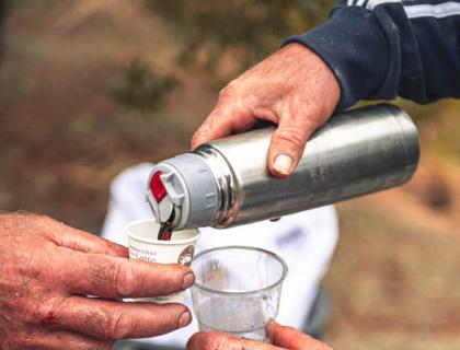 Due mani versano vino in bicchieri, simbolo di amicizia e condivisione.