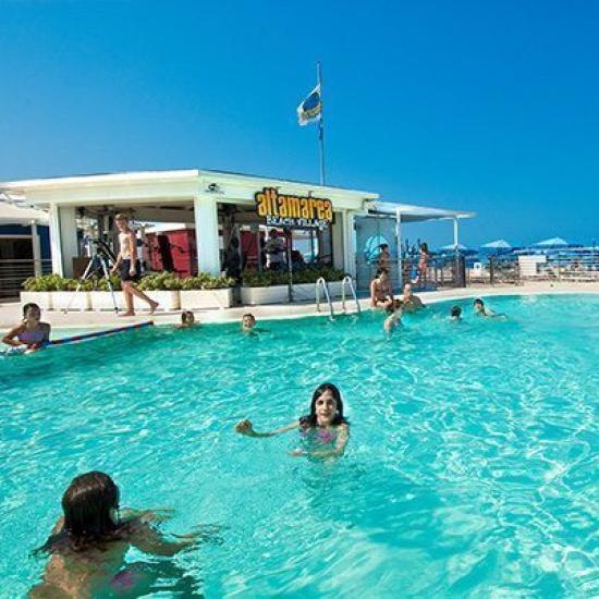 Piscina all'aperto con bar e vista sul mare.