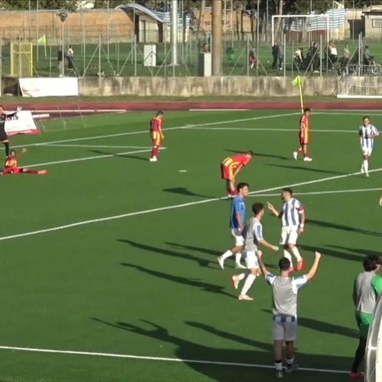 Giocatori di calcio in campo durante una partita, alcuni festeggiano.