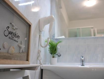 Bagno con decorazione marittima, asciugacapelli e pianta.