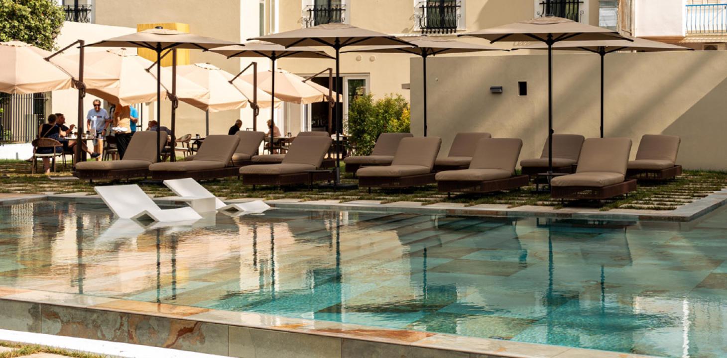 Piscina tranquilla con lettini e ombrelloni, atmosfera rilassante e accogliente.