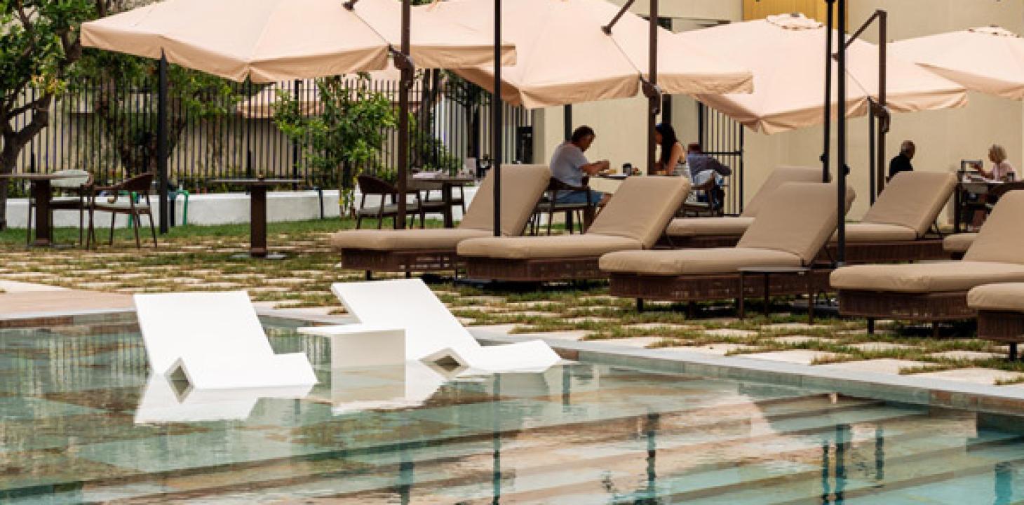 Piscina elegante con lettini e ombrelloni, atmosfera rilassante e accogliente.