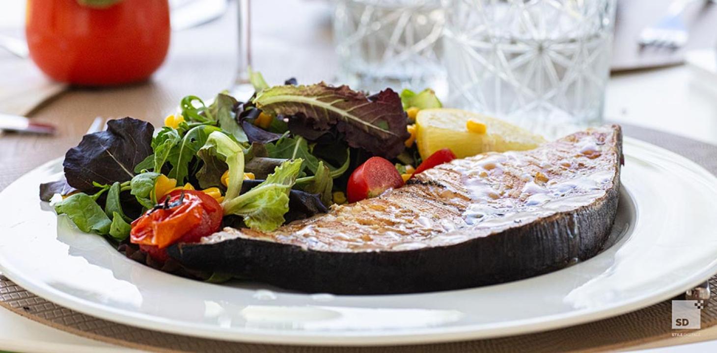 Pesce spada grigliato con insalata fresca e pomodorini.