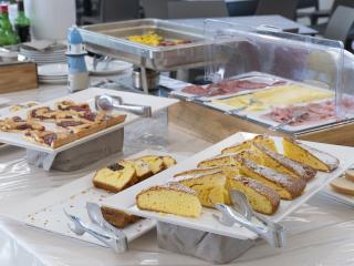 Reiches Buffet mit Gebäck und Aufschnitt, warme und einladende Atmosphäre.