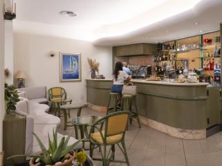 Gemütliche Bar mit grüner Einrichtung, entspannte Atmosphäre und nautischen Gemälden.