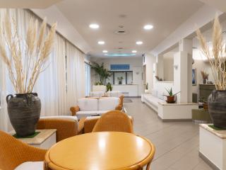 Elegante Lounge mit geflochtenen Stühlen, Pflanzen und sanfter Beleuchtung.