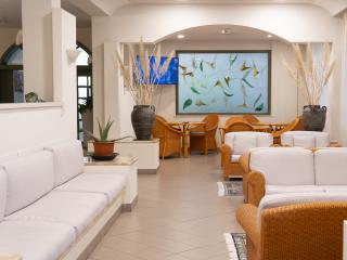 Elegante Lounge mit weißen Sofas, Pflanzen und natürlichen Dekorationen.