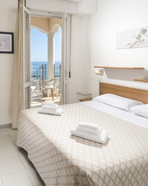 Camera luminosa con vista mare, letto accogliente e atmosfera rilassante.