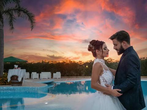 Wedding couple at sunset by a pool.