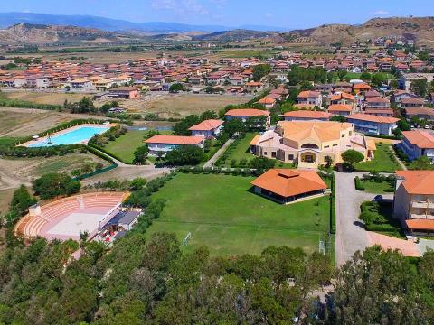 Aerial view of a residential complex with pool and amphitheater.