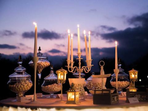 Elegant table with candles and sweets at sunset.