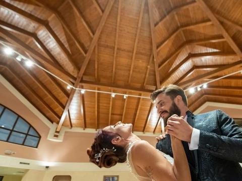 Couple dancing under an elegant wooden ceiling.