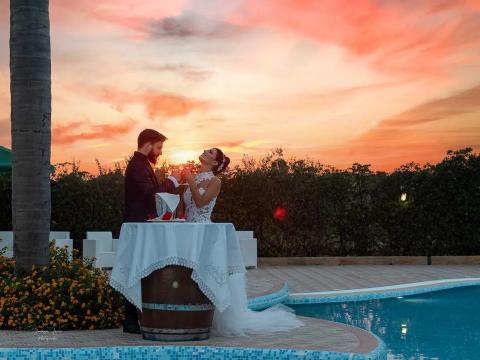 Couple celebrates at sunset by the pool.