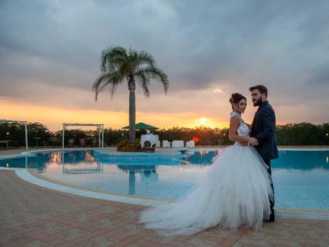 Wedding couple at sunset by the pool.