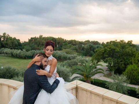 Bride and groom embracing on a terrace with a panoramic view.