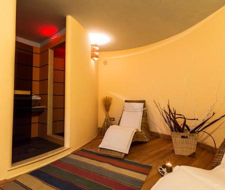 Sala relax con lettini, sauna e decorazioni naturali.
